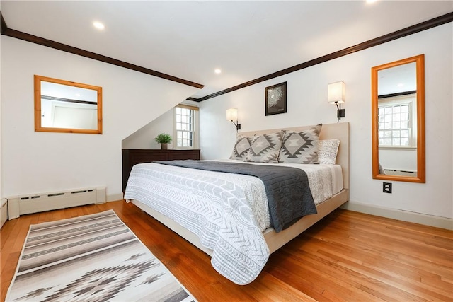 bedroom featuring hardwood / wood-style flooring, ornamental molding, and a baseboard radiator