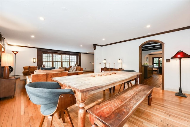 dining area featuring light wood-type flooring and crown molding