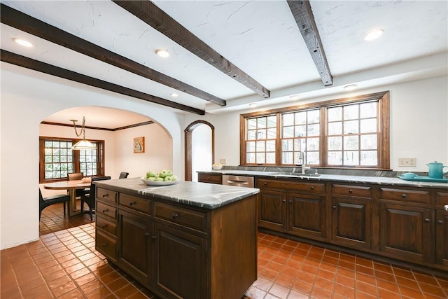 kitchen with a center island, sink, tile patterned floors, dark brown cabinets, and beamed ceiling