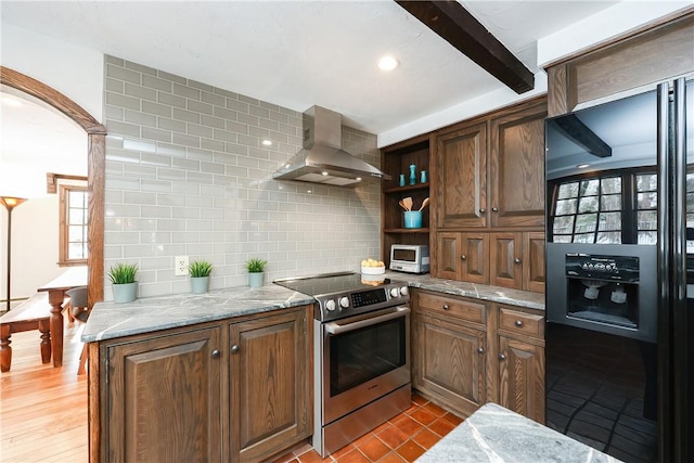 kitchen with black refrigerator with ice dispenser, light stone countertops, electric range, and wall chimney exhaust hood