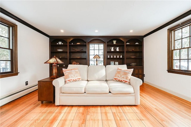 living room featuring a baseboard heating unit, plenty of natural light, ornamental molding, and light hardwood / wood-style floors