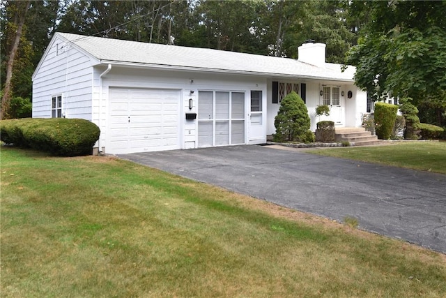 single story home featuring a garage and a front lawn