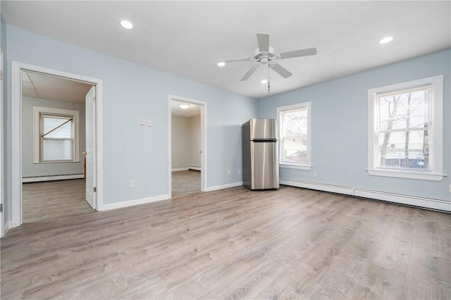 unfurnished bedroom featuring ceiling fan, stainless steel fridge, light hardwood / wood-style flooring, and a baseboard heating unit