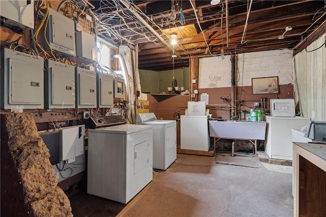 laundry area with washing machine and clothes dryer, electric panel, and sink