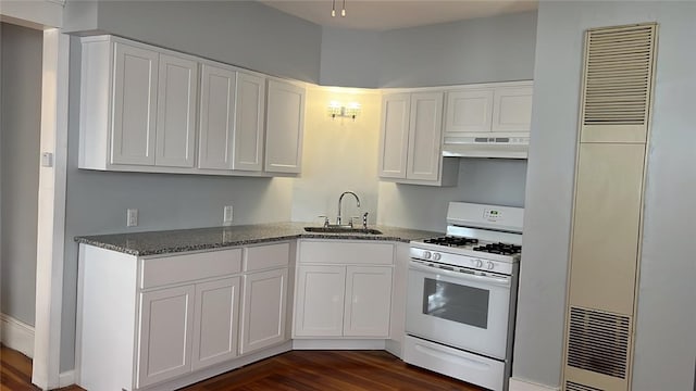 kitchen with light stone countertops, dark hardwood / wood-style flooring, white gas range oven, sink, and white cabinets