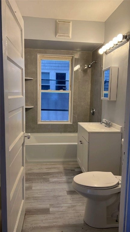 full bathroom featuring wood-type flooring, vanity, toilet, and tiled shower / bath