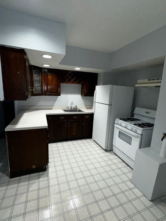 kitchen with dark brown cabinetry, sink, white appliances, and ventilation hood