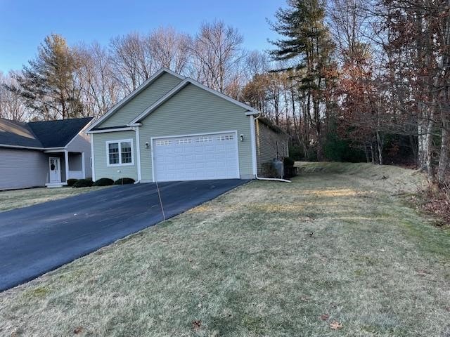 view of property exterior with a yard and a garage