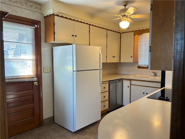 kitchen featuring dishwasher, black electric stovetop, white refrigerator, sink, and ceiling fan