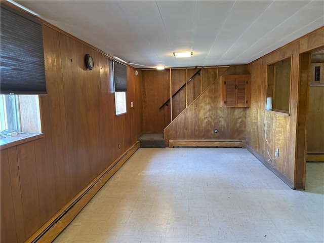 basement featuring baseboard heating and wood walls