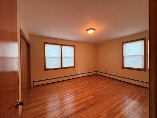 spare room with light wood-type flooring and a baseboard radiator