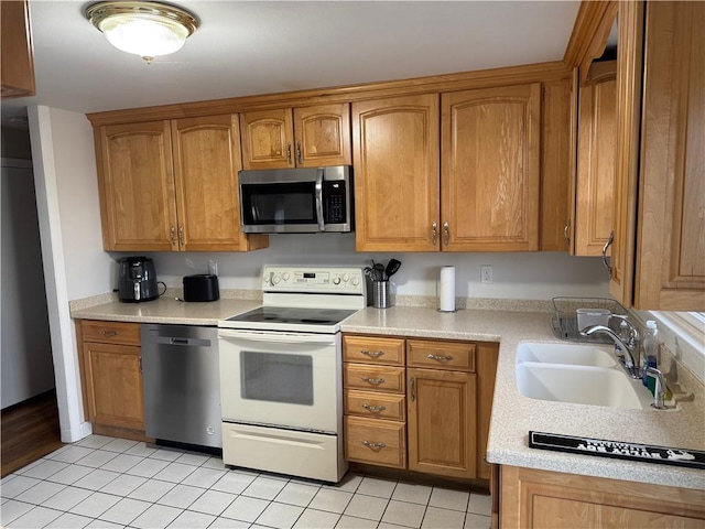 kitchen with sink, light tile patterned floors, and stainless steel appliances