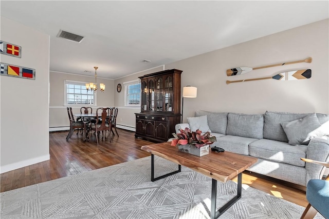 living area featuring a baseboard radiator, visible vents, a notable chandelier, and wood finished floors