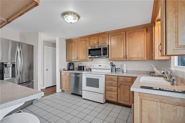 kitchen featuring stainless steel appliances, light countertops, a sink, and light tile patterned floors