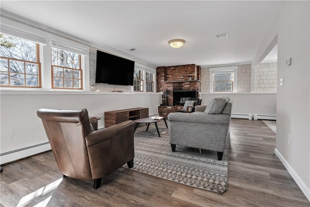 living area featuring a fireplace, baseboard heating, and wood finished floors