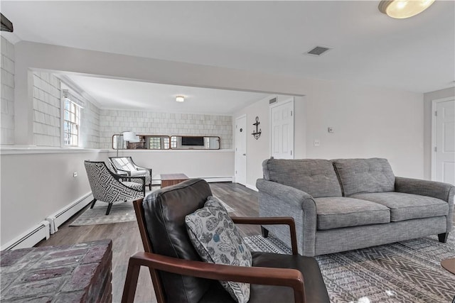 living room featuring visible vents, baseboards, and wood finished floors