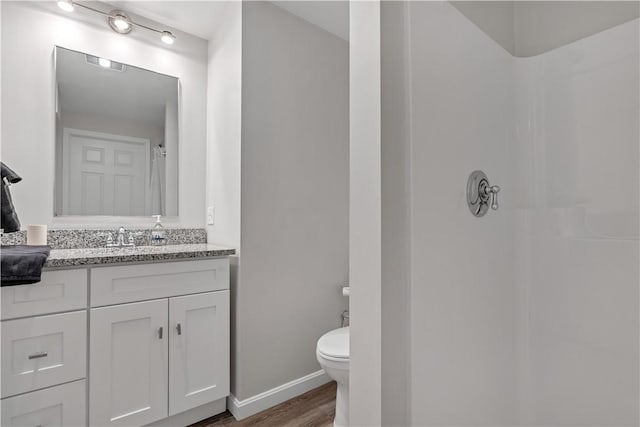 full bathroom with curtained shower, toilet, vanity, wood finished floors, and baseboards