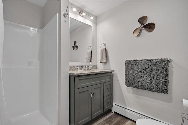 bathroom with a baseboard radiator, walk in shower, wood finished floors, and vanity