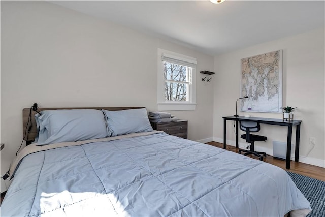 bedroom with baseboards and wood finished floors