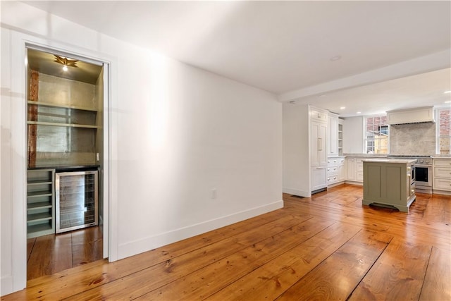 unfurnished living room featuring light wood-type flooring and beverage cooler