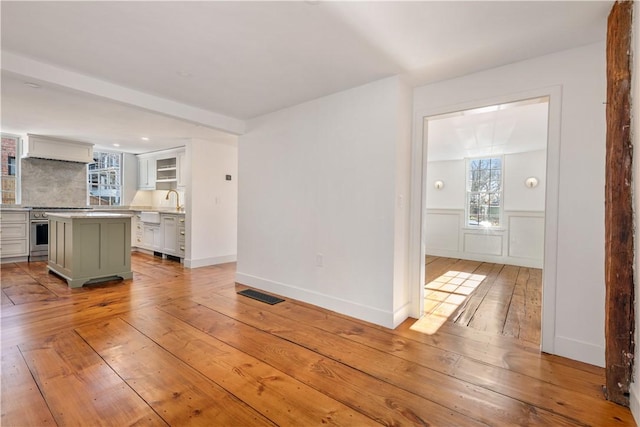 interior space featuring light hardwood / wood-style flooring, a kitchen island, and stainless steel stove