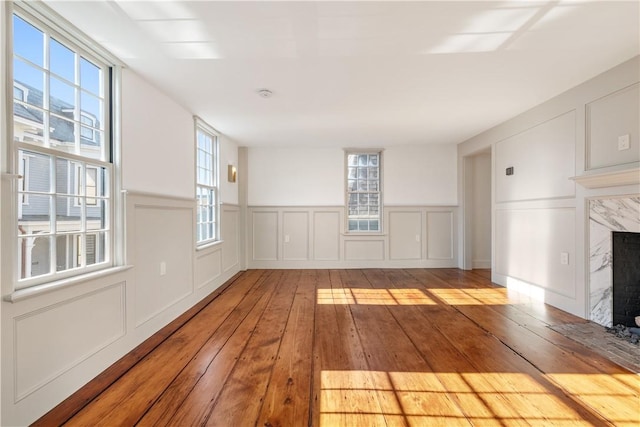 unfurnished living room featuring a premium fireplace and light wood-type flooring