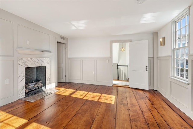 unfurnished living room with a premium fireplace and light hardwood / wood-style flooring