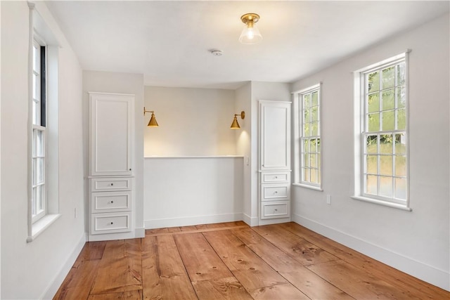 unfurnished bedroom featuring light wood-type flooring and multiple windows