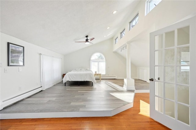 unfurnished bedroom featuring a baseboard radiator, ornate columns, ceiling fan, and light hardwood / wood-style floors