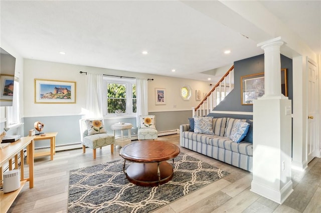 living room featuring decorative columns, a baseboard radiator, and light wood-type flooring