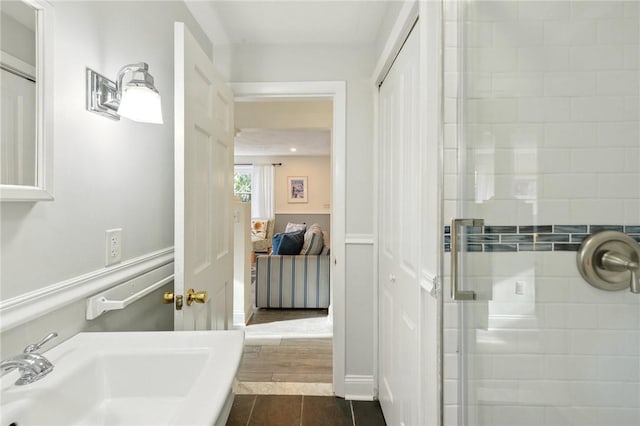 bathroom with tile patterned flooring, walk in shower, and sink