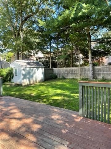 wooden terrace featuring a yard and a storage shed