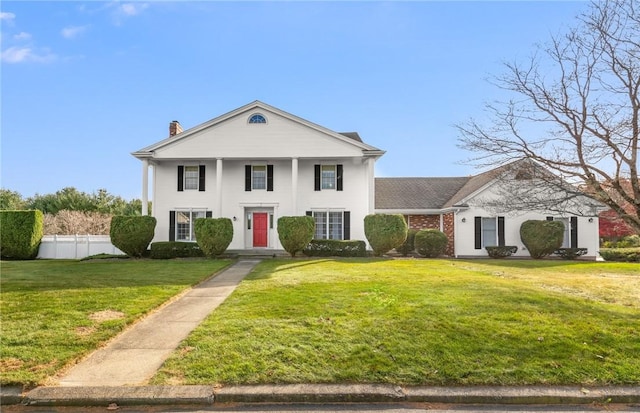 greek revival inspired property featuring a front lawn