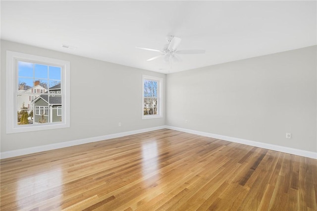 empty room with ceiling fan and light hardwood / wood-style floors