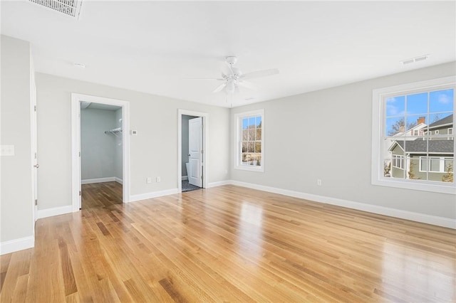 spare room with ceiling fan, a healthy amount of sunlight, and light wood-type flooring