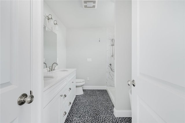 bathroom with vanity, toilet, and a shower