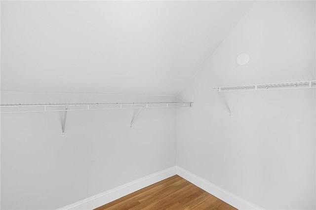 spacious closet featuring hardwood / wood-style floors and vaulted ceiling