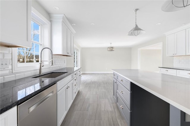 kitchen featuring dishwasher, sink, tasteful backsplash, decorative light fixtures, and white cabinets