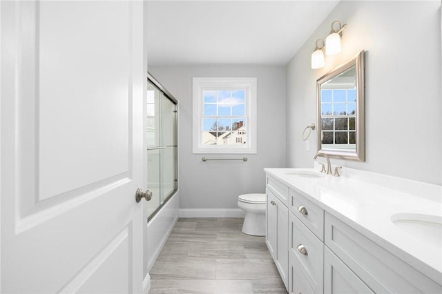 full bathroom with shower / bath combination with glass door, vanity, and toilet