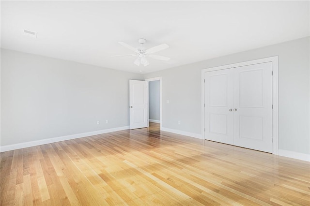 unfurnished bedroom with ceiling fan, a closet, and light wood-type flooring