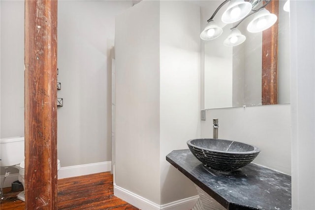 bathroom with hardwood / wood-style flooring, toilet, and sink