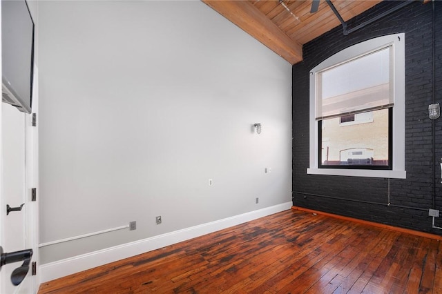 unfurnished room featuring vaulted ceiling with beams, hardwood / wood-style flooring, ceiling fan, and wooden ceiling