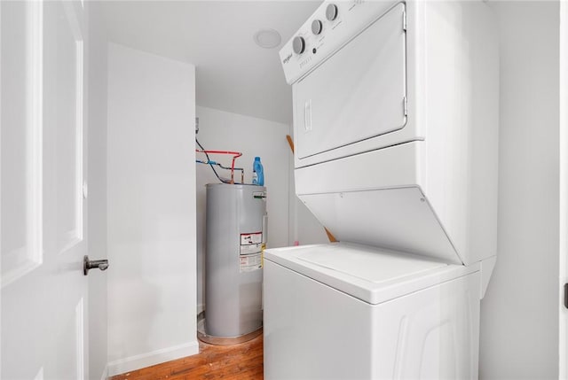 laundry area with hardwood / wood-style floors, electric water heater, and stacked washer and dryer