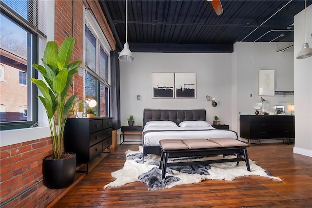 bedroom featuring dark hardwood / wood-style flooring, multiple windows, and ceiling fan