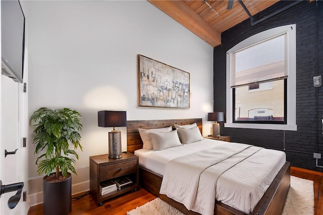 bedroom featuring wood-type flooring, vaulted ceiling with beams, and wood ceiling