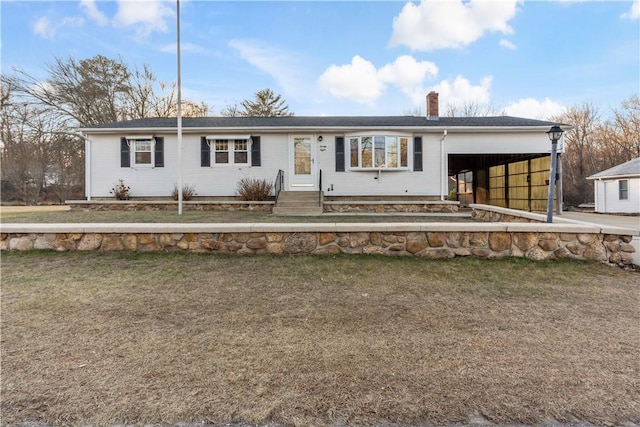 ranch-style house with a front yard and a carport