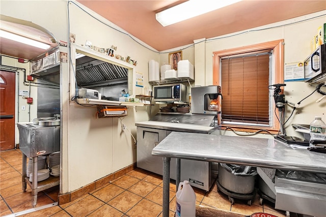 kitchen with light tile patterned floors and stainless steel counters