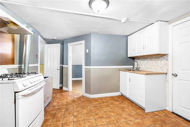 kitchen featuring white cabinetry, sink, range hood, backsplash, and white range with gas cooktop