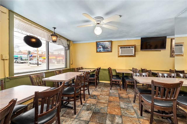 dining space featuring a wall mounted air conditioner and ceiling fan