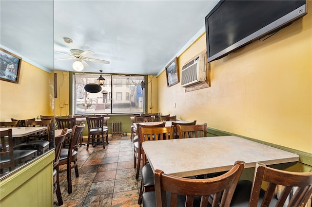 dining space featuring ceiling fan, radiator heating unit, ornamental molding, and a wall mounted AC